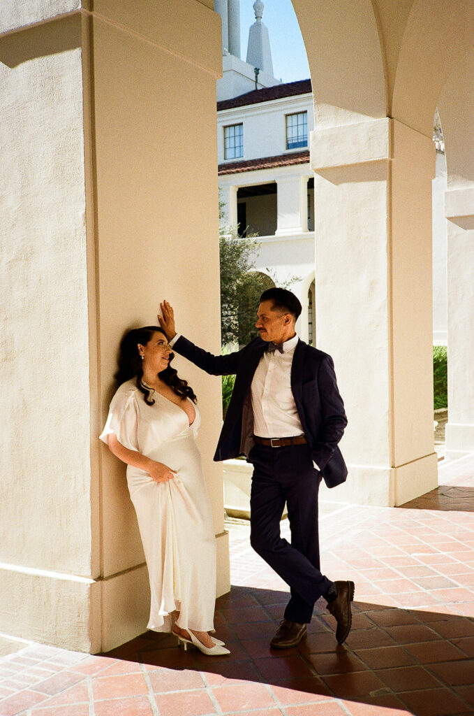 Editorial film style portrait of a bride and groom posing.