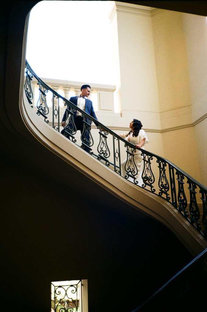 Film photo of a bride and groom ascending the staircase.