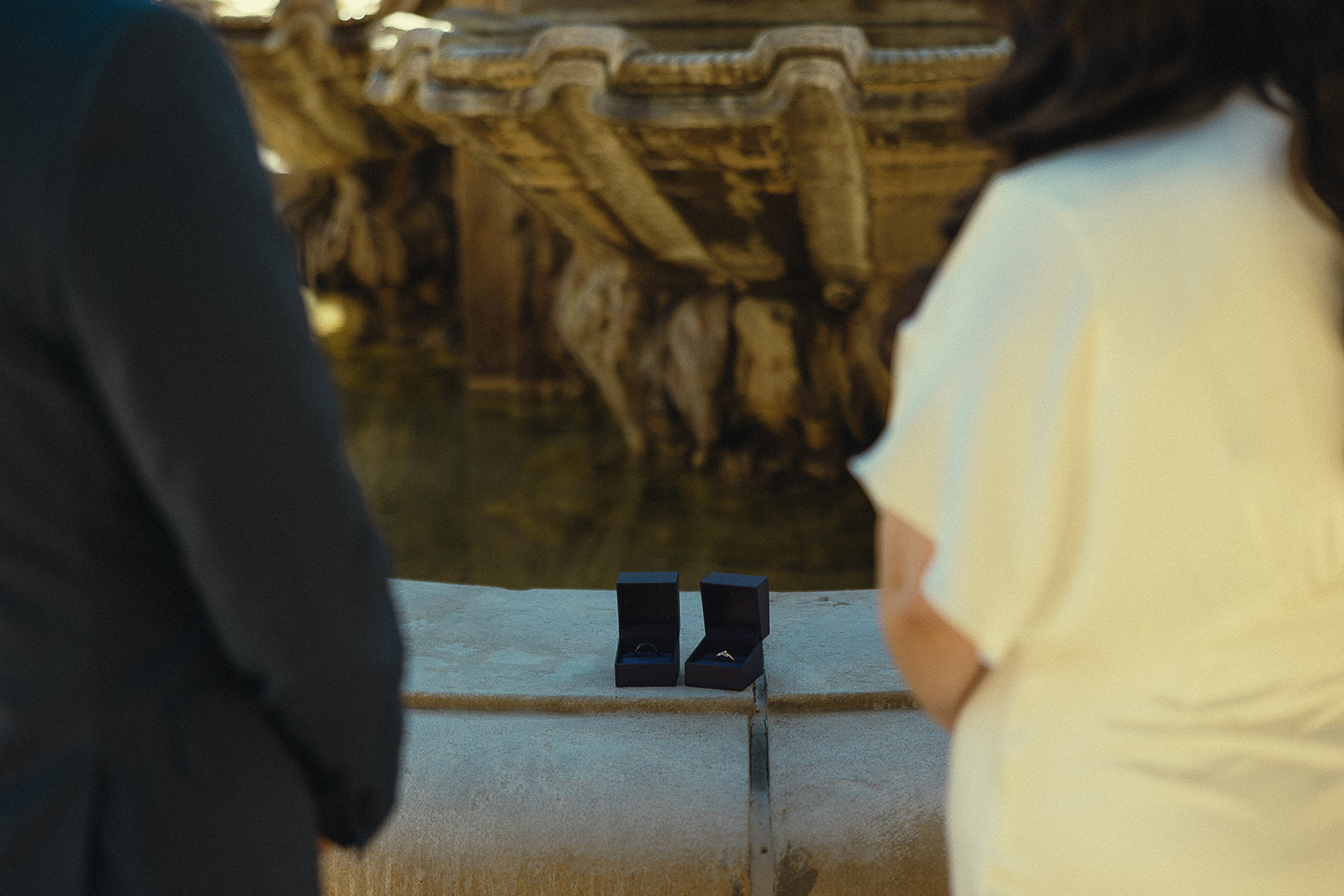 Close up shot of the bride and grooms ring boxes resting on the fountain outside of the Pasadena City Hall.