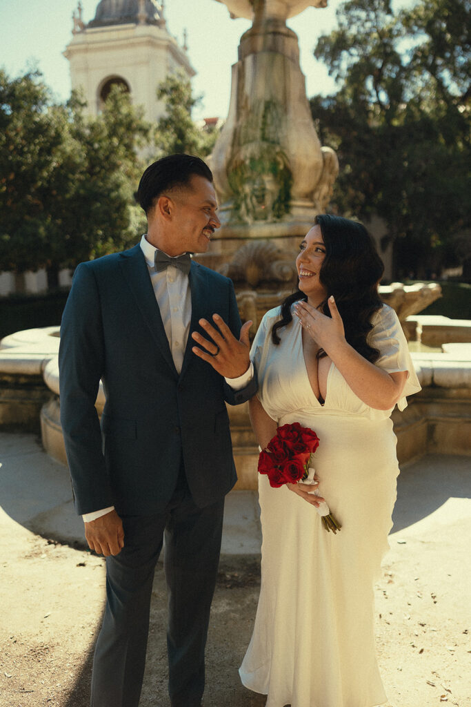 Couple smiling and and showing off their wedding rings after their intimate ceremony.