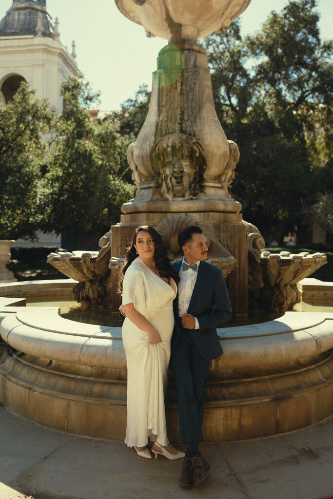 Editorial style elopement portrait of a couple posing in front of the fountain for their Pasadena City Hall elopement.