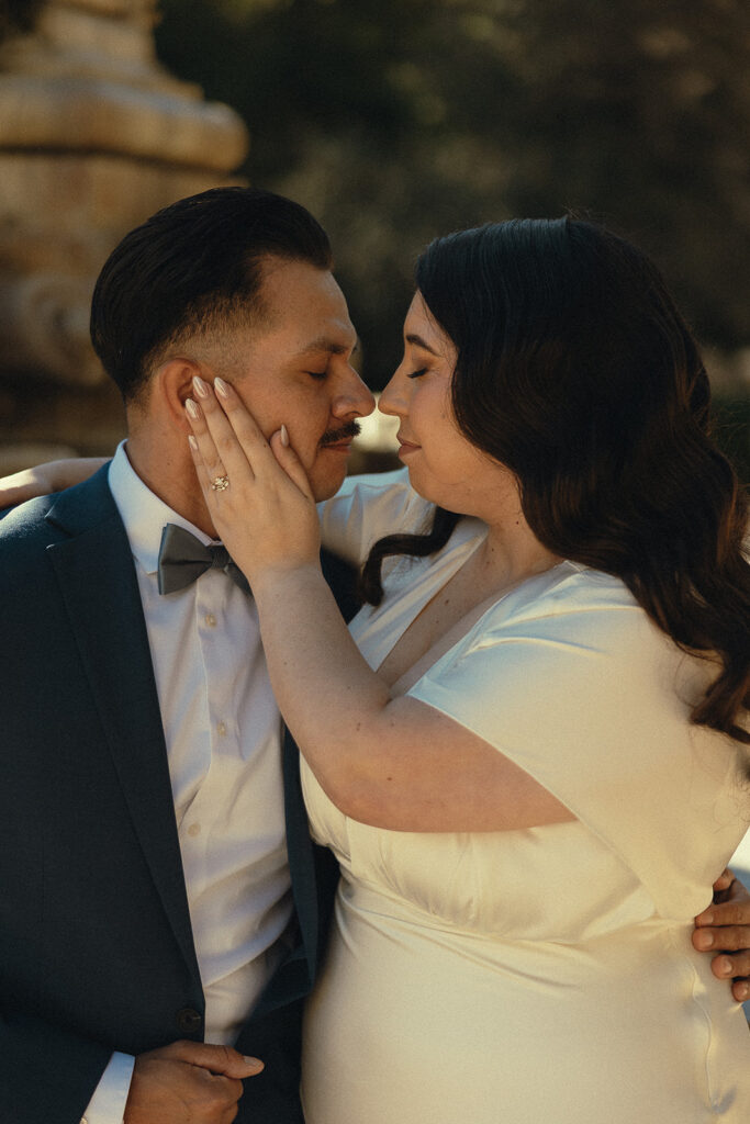Close up shot of the bride caressing her grooms face during their intimate wedding portraits.