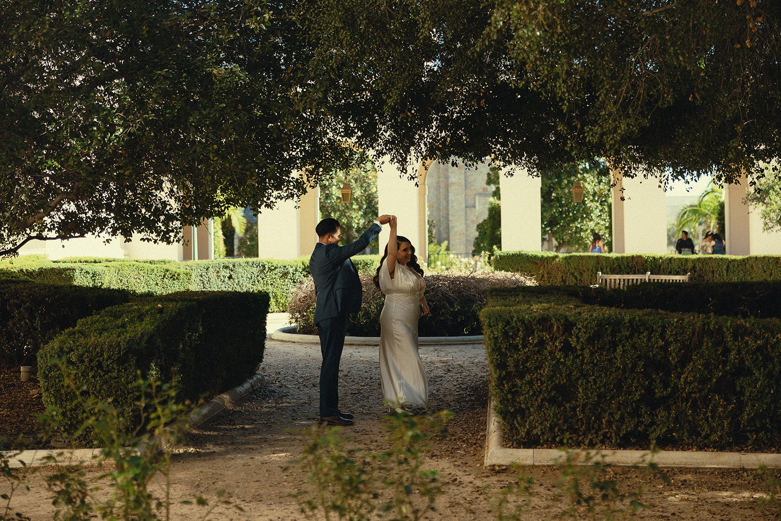 Man twirling his bride in the courtyard.