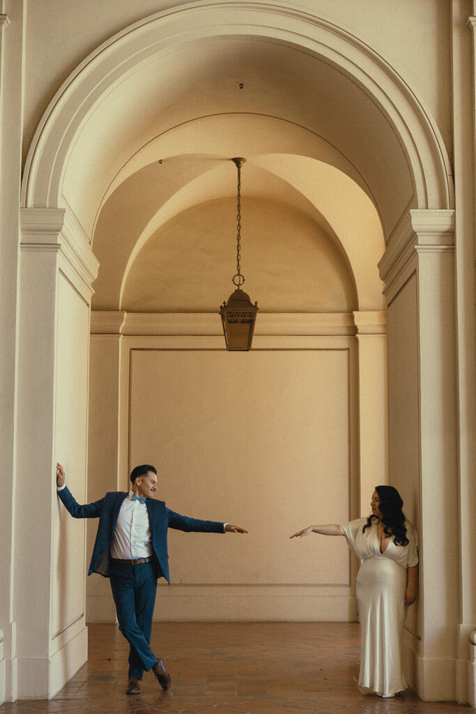 Couple standing across from one another and reading their hands out during their elopement photoshoot.
