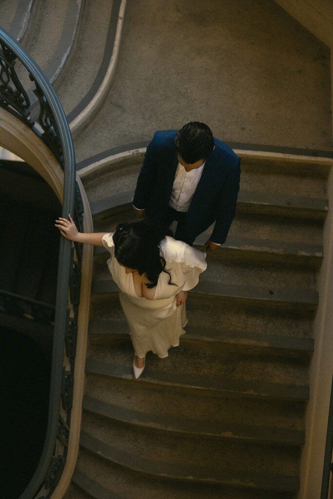 Overhead shot of the couples holding hands and walking down the stairs.