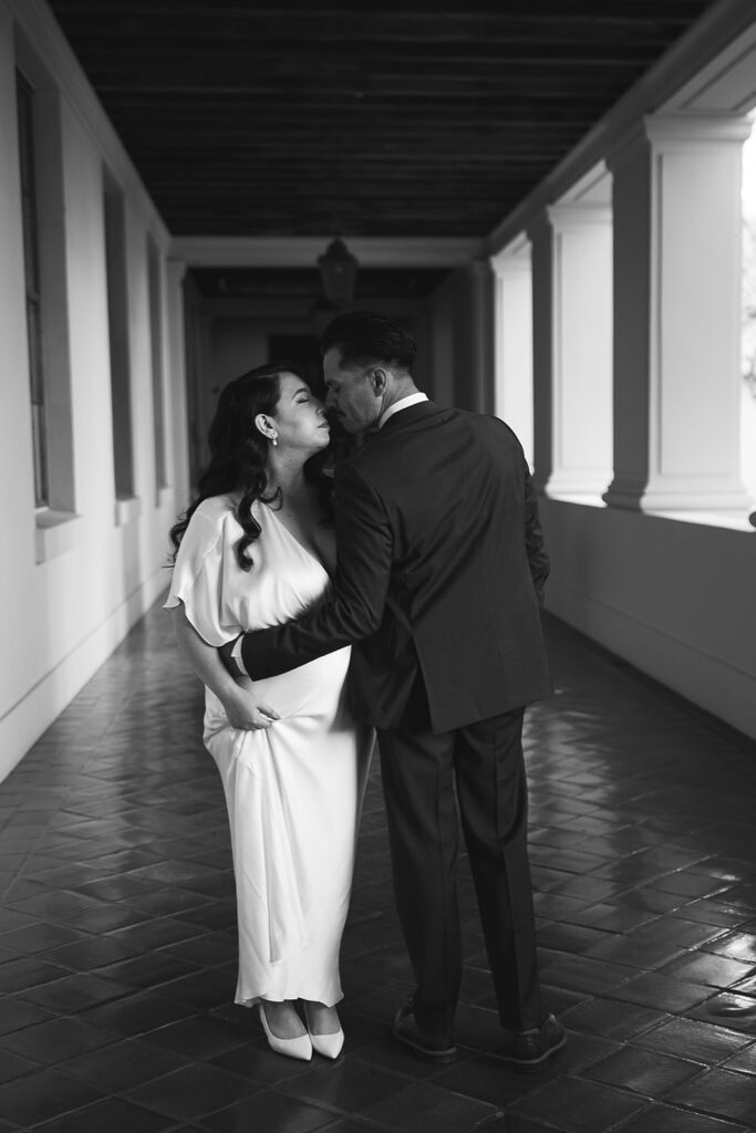 Black and white photo of a couple touching noses. 