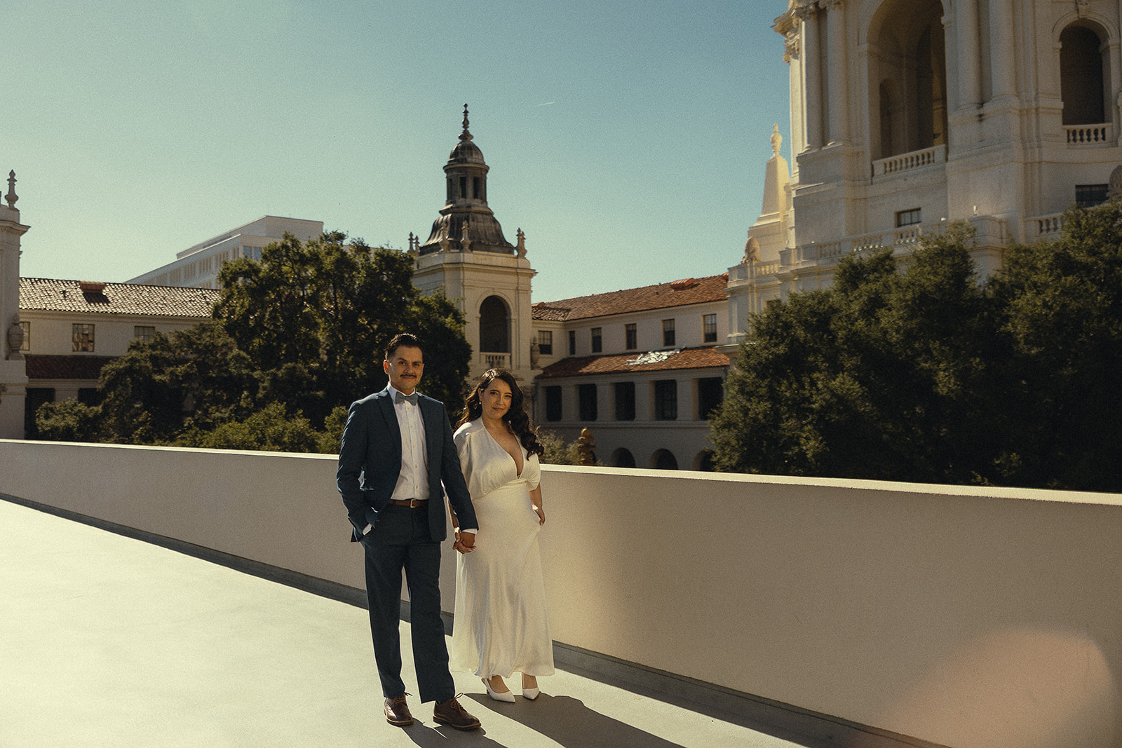 Couple holding hands and walking on a rooftop.
