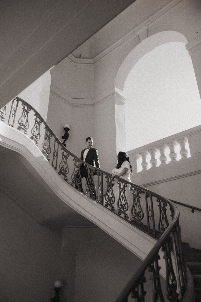 Black and white photo of a couple walking up the stairs.