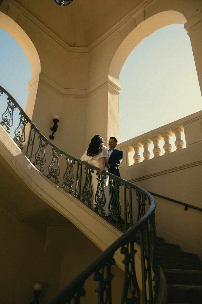 Couple leaning against the staircase during their Pasadena City Hall elopement photos. 