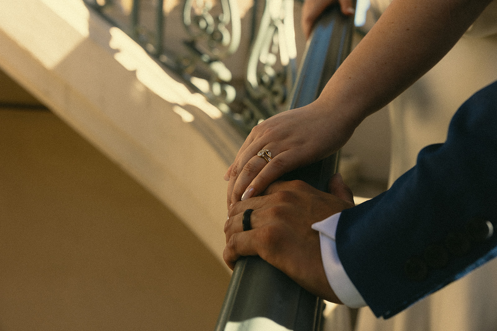 Close up shot of a couple holding hands on the stiarcase.