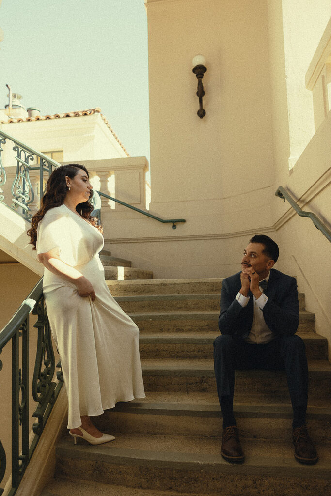 Couple posing at the bottom of a stiarcase.