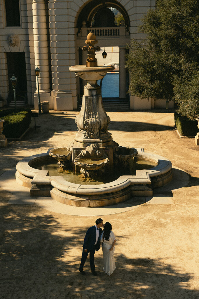 Far away overhead shot of a couple kissing in the courtyard at Pasadena City Hall.