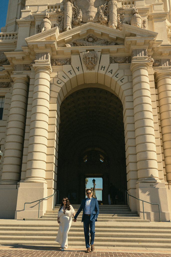 Bridfe and groom walking outside of the city hall.