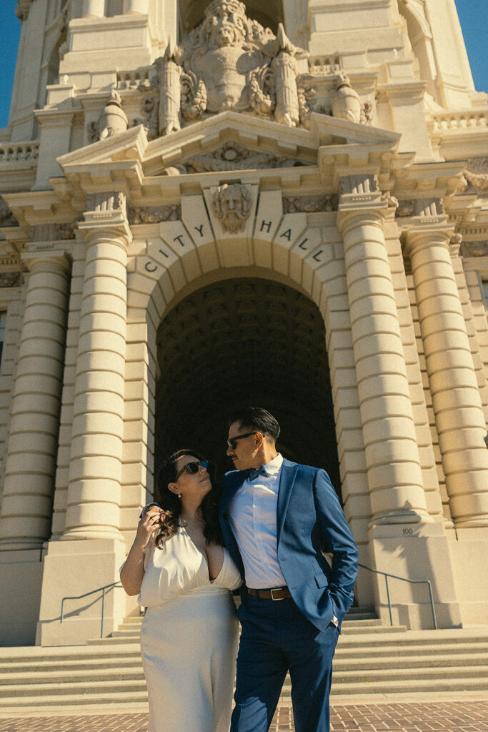 Couple posing outside of the city hall.