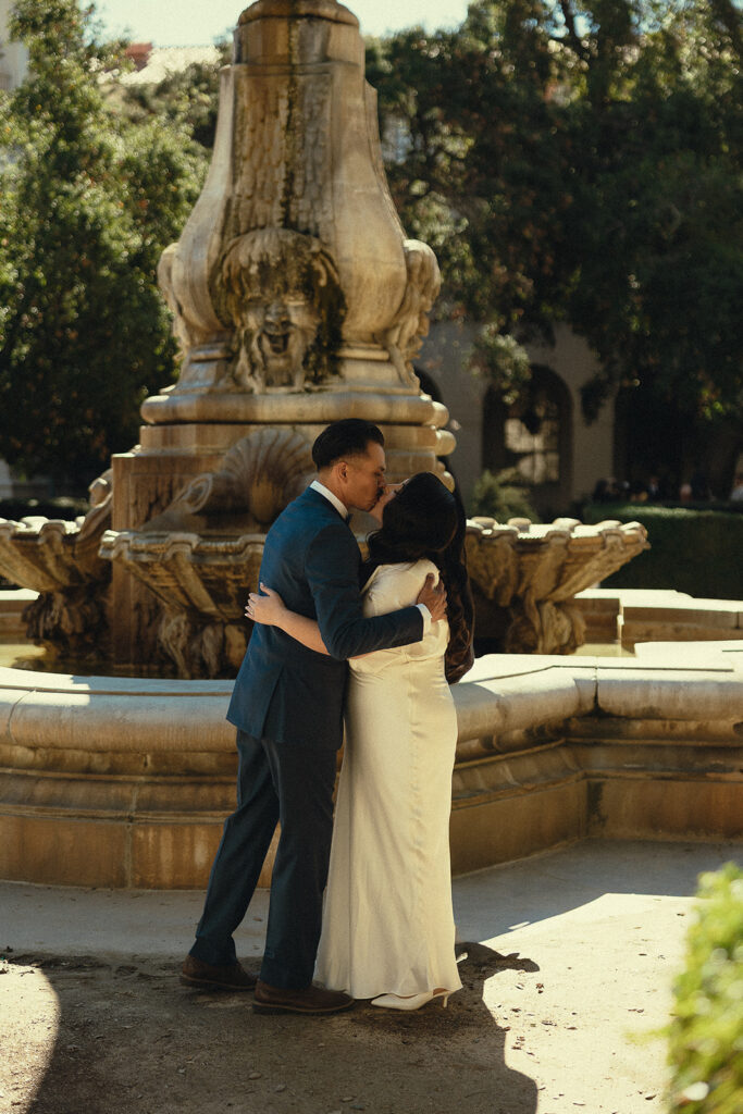 Bride and groom kissing in front of the fountain outside of The Pasadena City Hall.