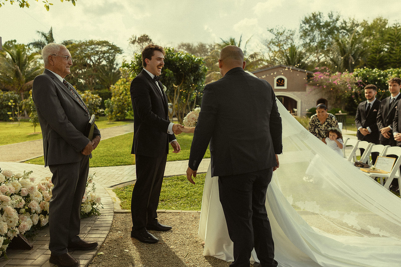Bride meeting the groom at the end of the aisle for their Cinco Farm Gardens Miami wedding ceremony.