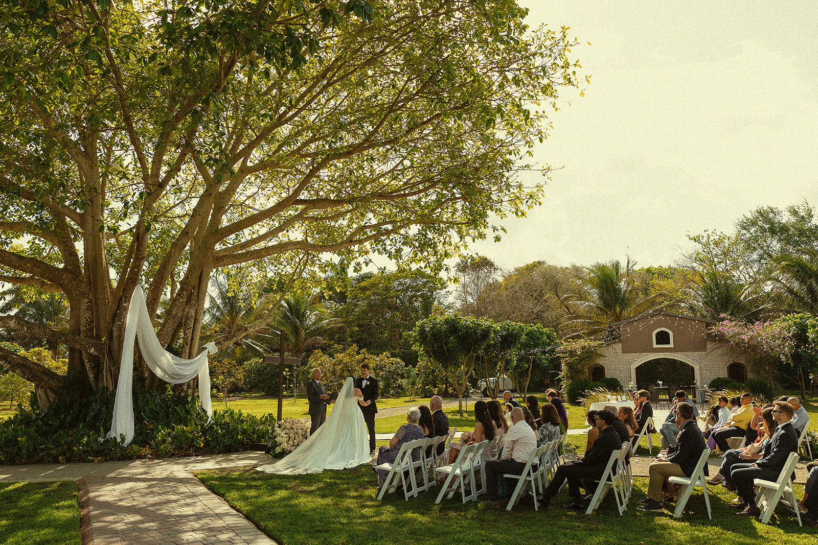 Wide shot of an outdoor Cinco Farm Gardens wedding ceremony in Miami, Florida.