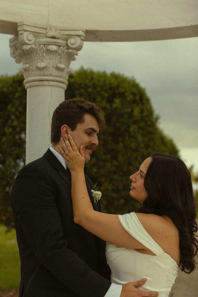 Close up portrait of a bride touching the grooms face lovingly. 