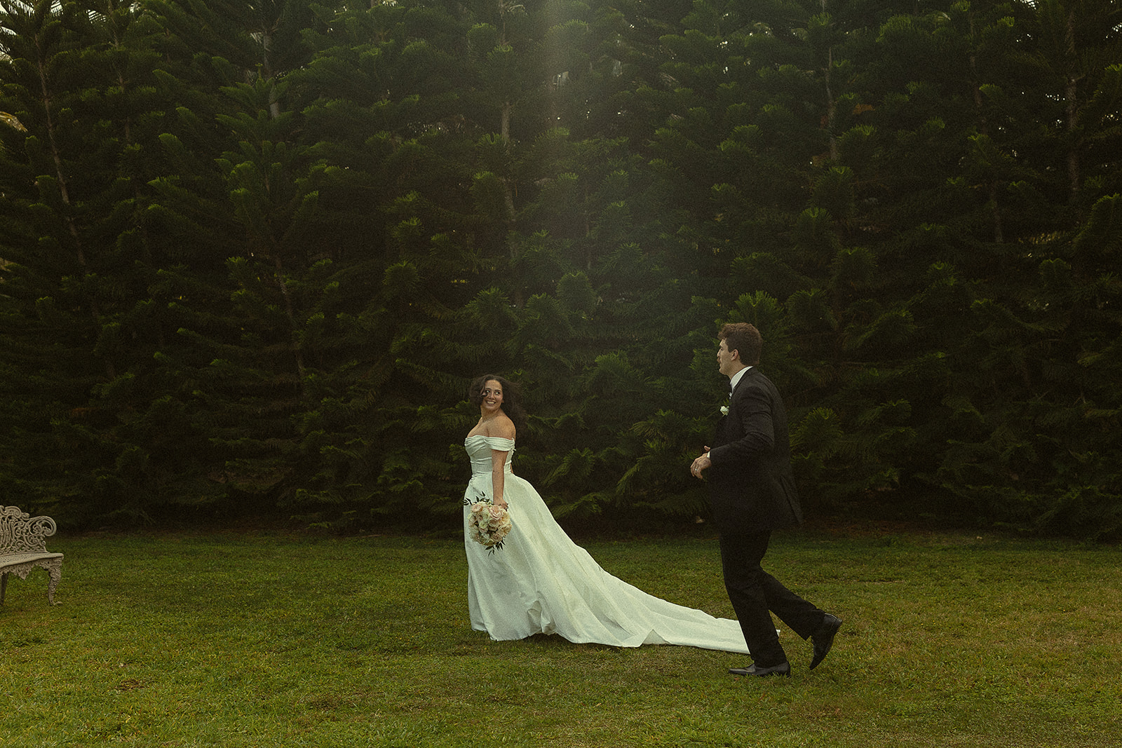 Bride and groom running through garden for wedding portraits.