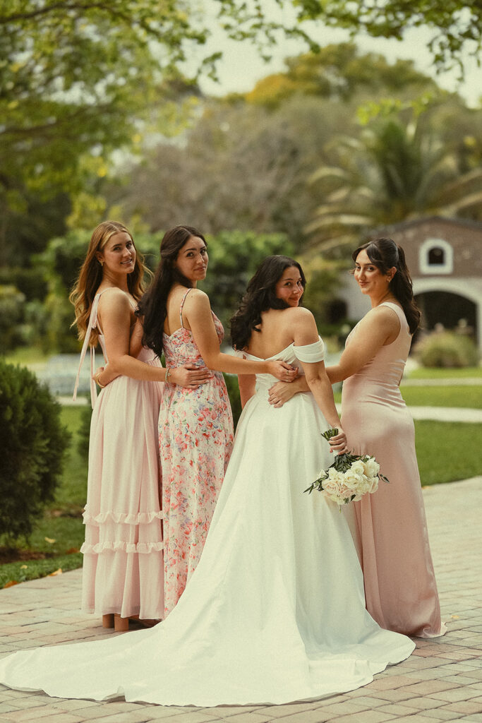 Bride and bridesmaids in pink dresses at Miami wedding venue.