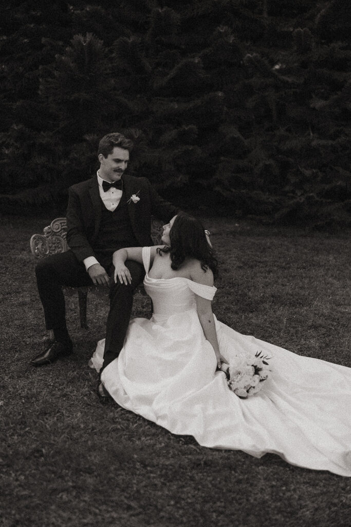 Bride and groom portrait on garden bench.