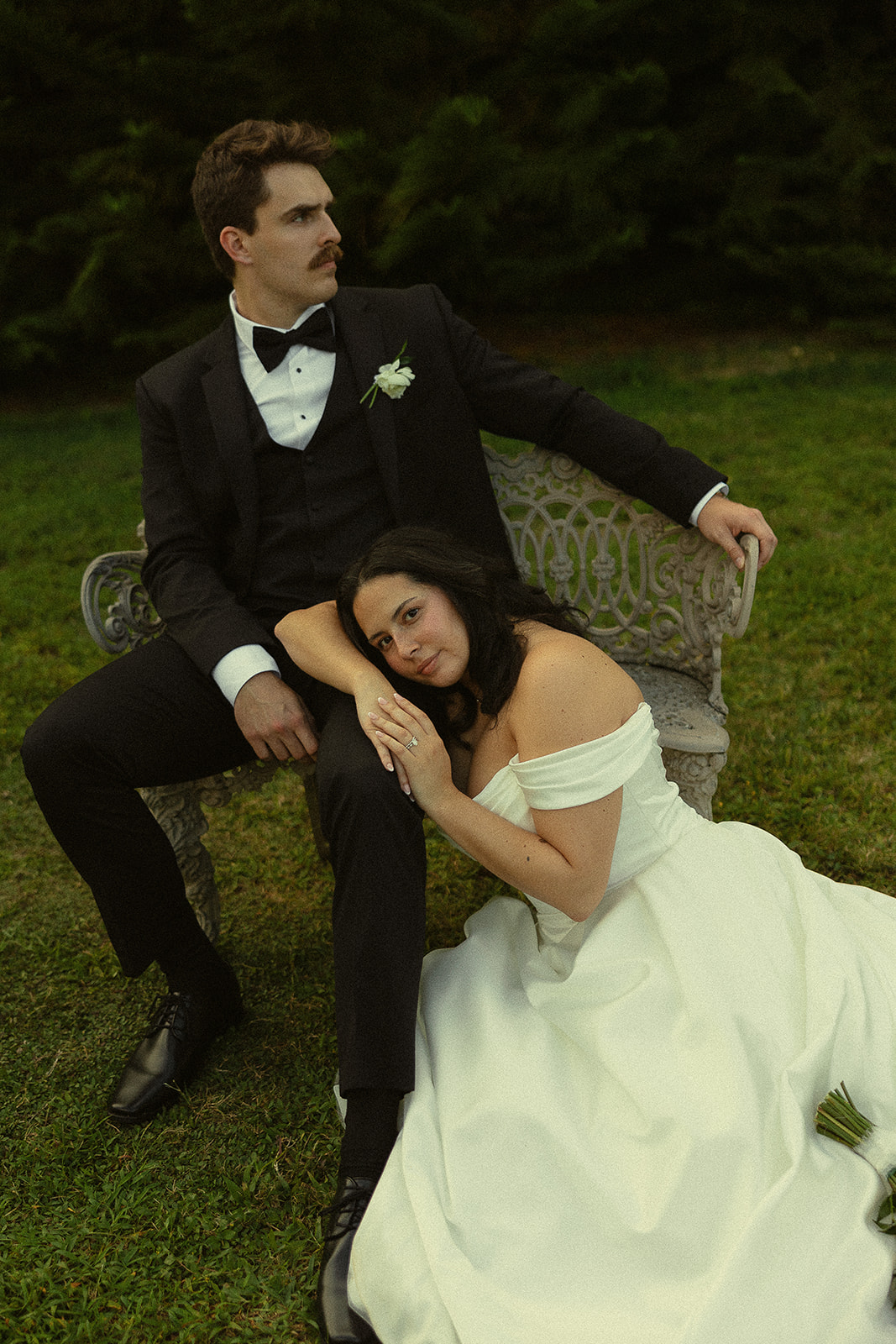 Bride and groom portrait on garden bench.
