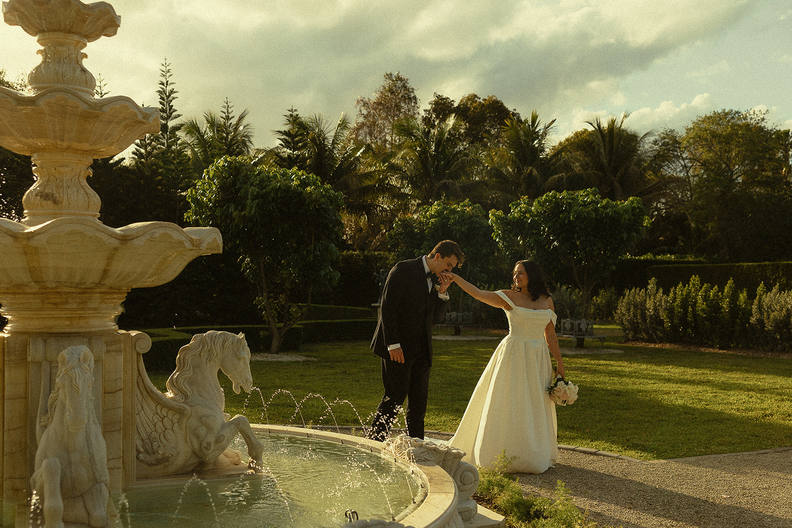 Bride and groom by water fountain at Cinco Farm Gardens.