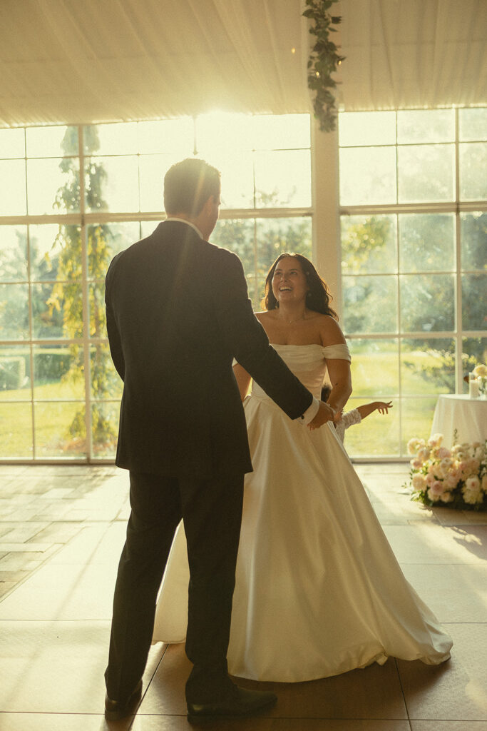 Bride and groom sharing their first dance in the glass pavilion.