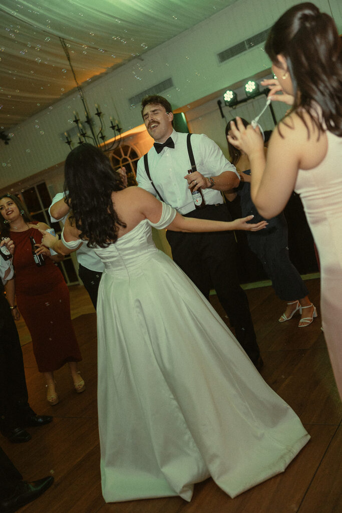 Bride and groom dancing with bubbles during their reception.