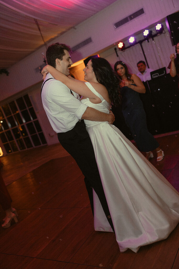 Bride and groom smiling together on the dance floor.