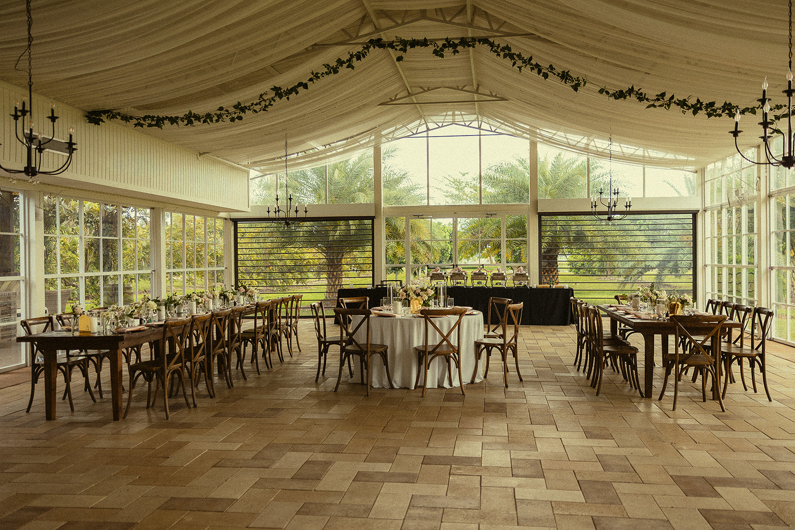 Wedding reception setup inside the glass pavilion at Cinco Farm Gardens.