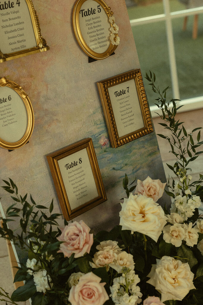 Gold framed seating chart with florals for Miami wedding reception.