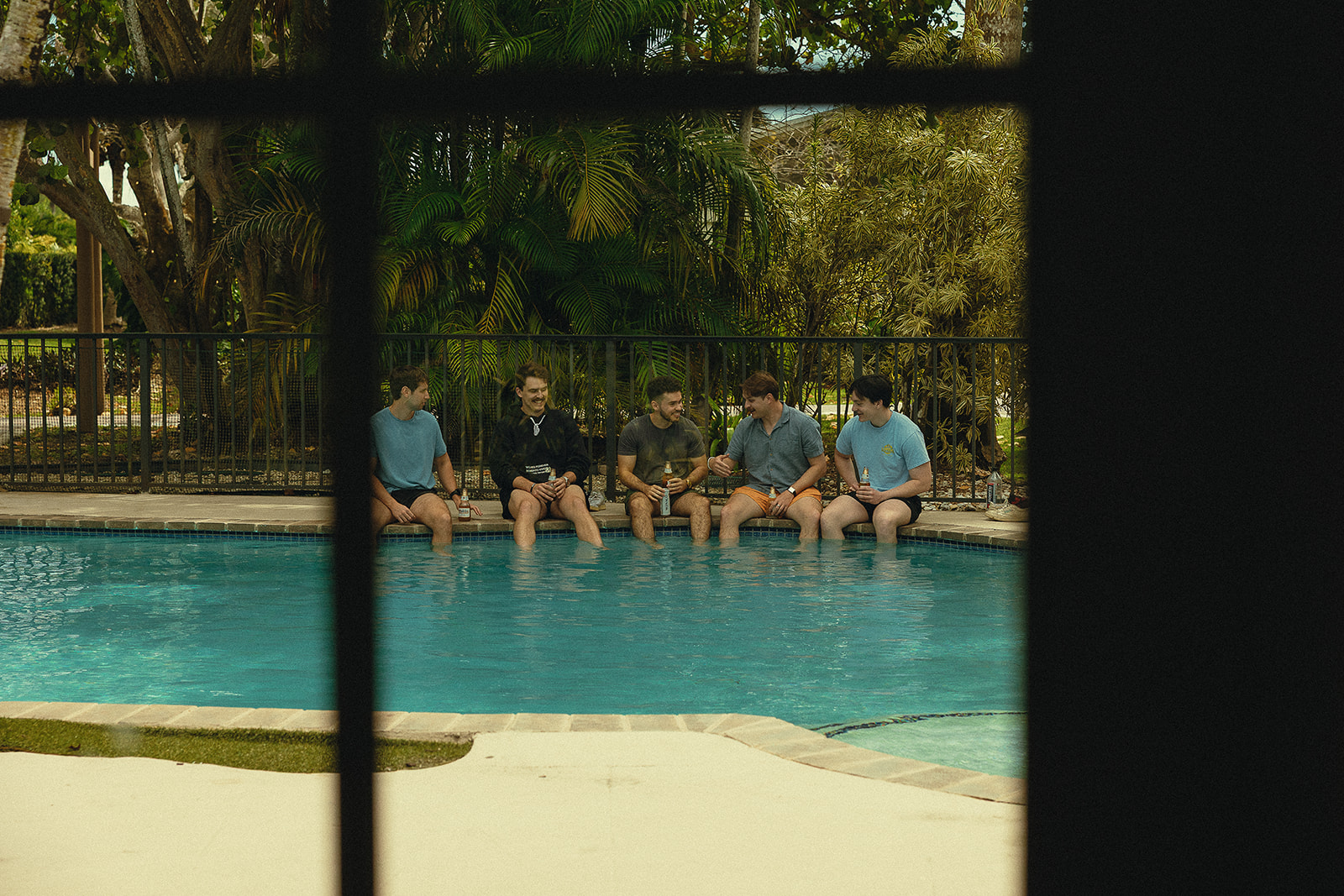 Groomsmen relaxing by the pool before a Miami wedding.