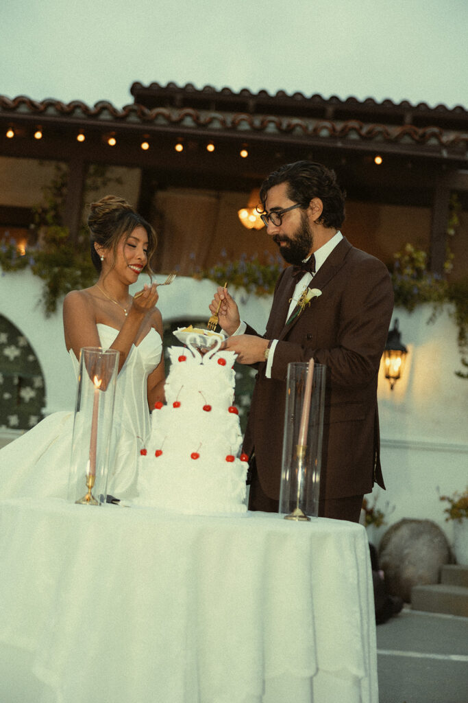 Bride and groom digging into their wedding cake during the reception.