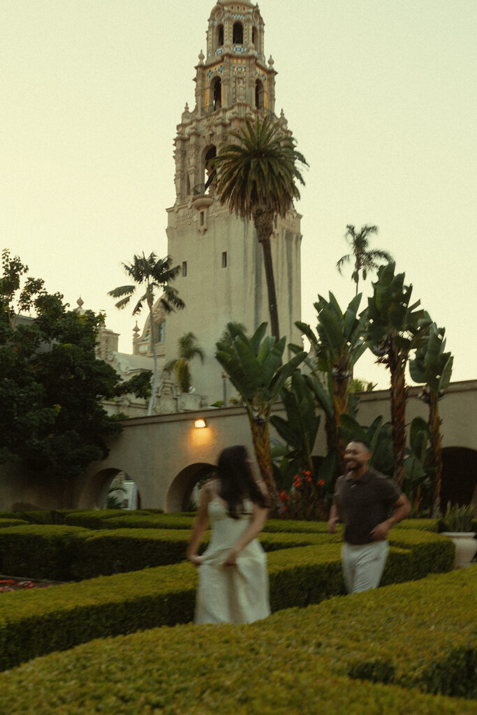 Couple laughing together in Alcazar Garden during their Balboa Park engagement session.