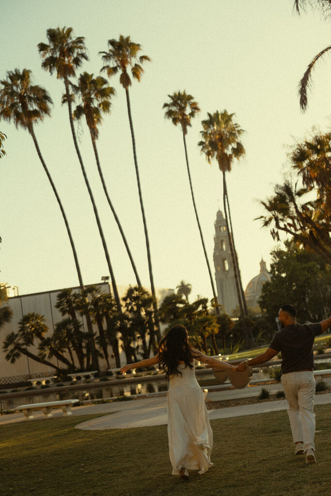 Couple running inside of Balboa Park for their dreamy and cinematic engagement photos.