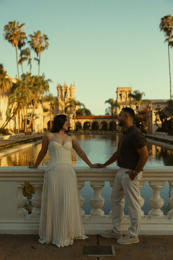 Couple standing by the Lily Pond during golden hour engagement photos at Balboa Park.