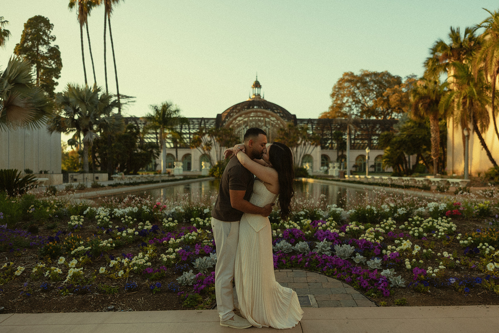 Couple kissing in front of the Botanical Building and Lily Pond at Balboa Park
