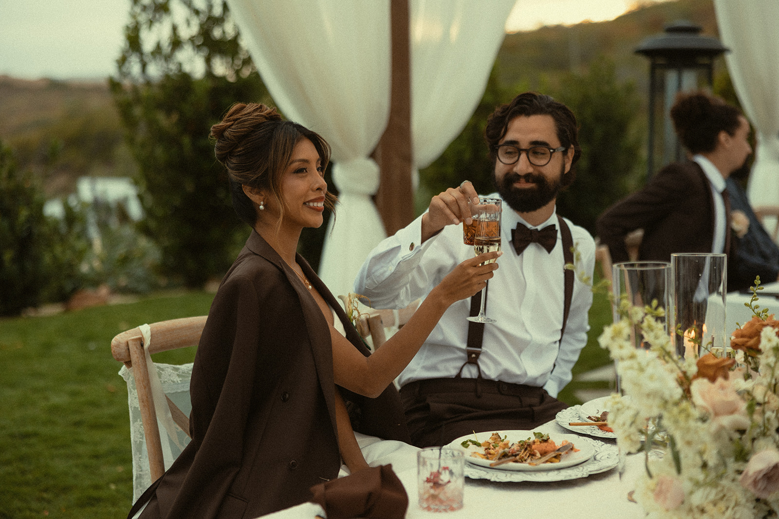 Bride and groom toasting their drinks during speeches.
