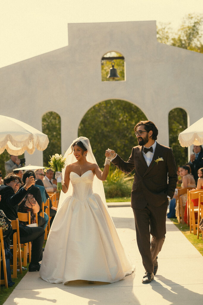 Bride and groom walking back down the aisle as husband and wife after their Jeune Perché wedding ceremony.